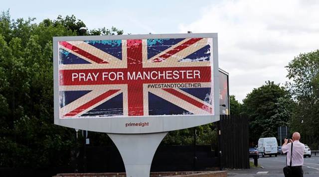 A man photographs a sign in Manchester, Britain May 23, 2017. REUTERS/Stefan Wermuth