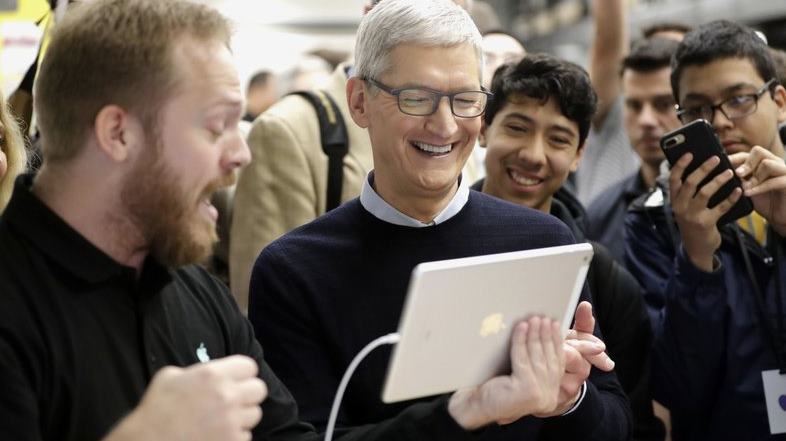 FILE- In this March 27, 2018, file photo Apple CEO Tim Cook smiles as he watches a demonstration on an iPad at an Apple educational event at Lane Technical College Prep High School in Chicago. New iPads and Mac computers are expected Tuesday, Oct. 30, as part of an Apple event in New York. (AP Photo/Charles Rex Arbogast, File)