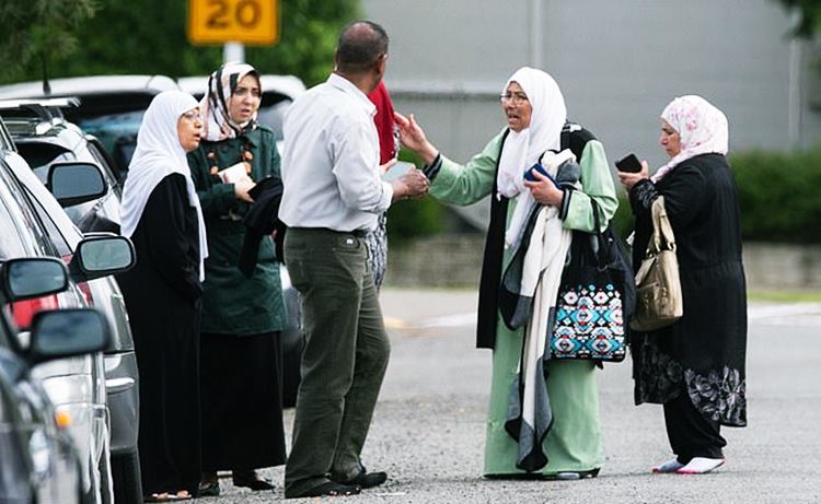 Shocked family members wait outside the mosque